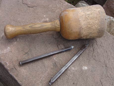 Bildhauerhammer und Meißel auf Stein